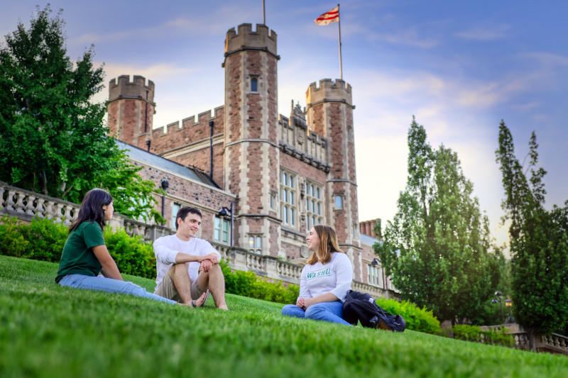 Students lounging in grass in front of Danforth building