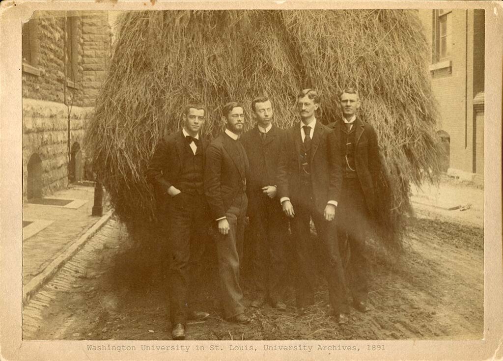 Five Washington University students pose in front of a hay cart in downtown St. Louis in 1891