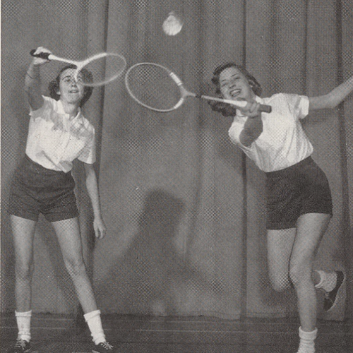 Black and white photo of two women playing badminton