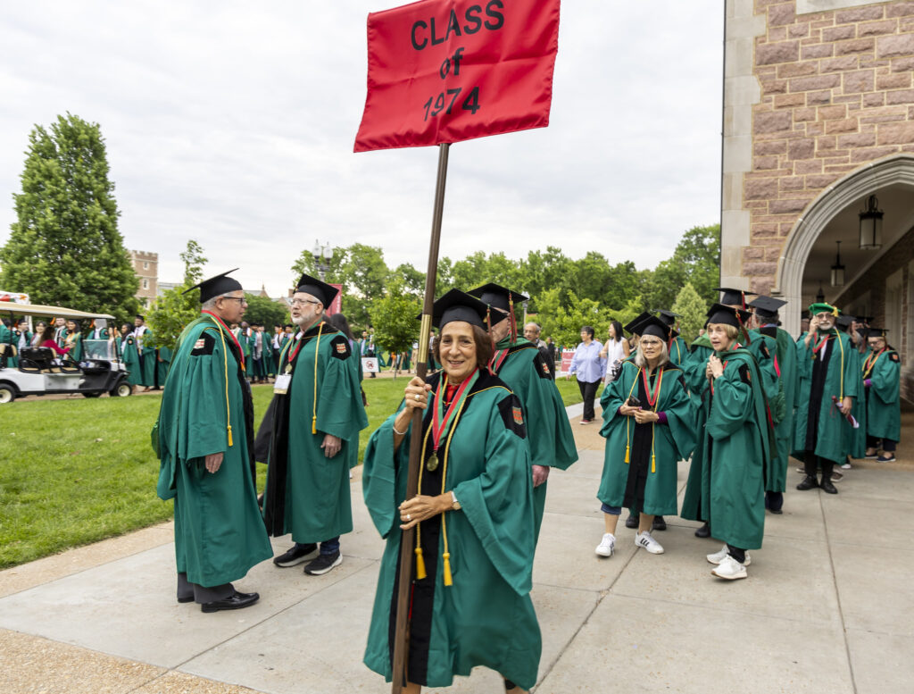 A Golden Bear alum holds the Class of 1974 sign at commencement