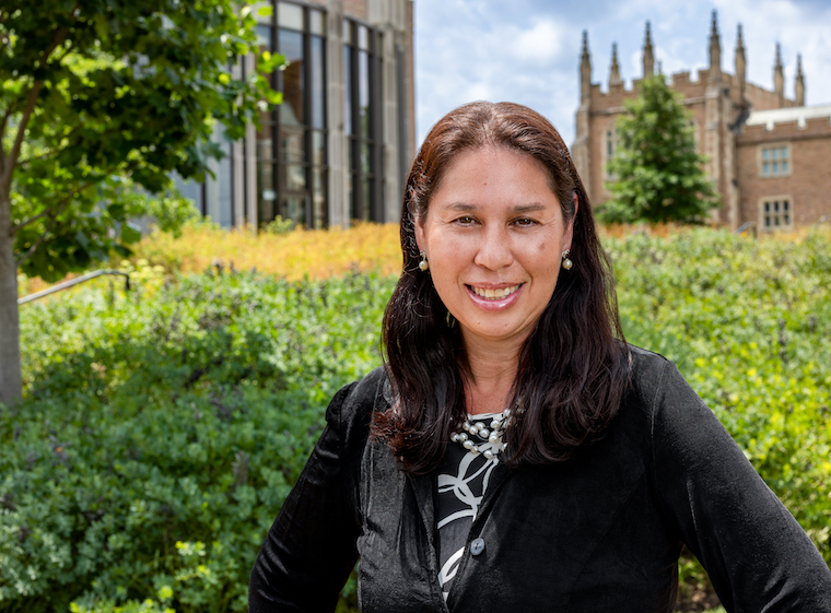 Color portrait of alumna Patricia Saleeby in front of Brown and Hillman halls on the WashU campus