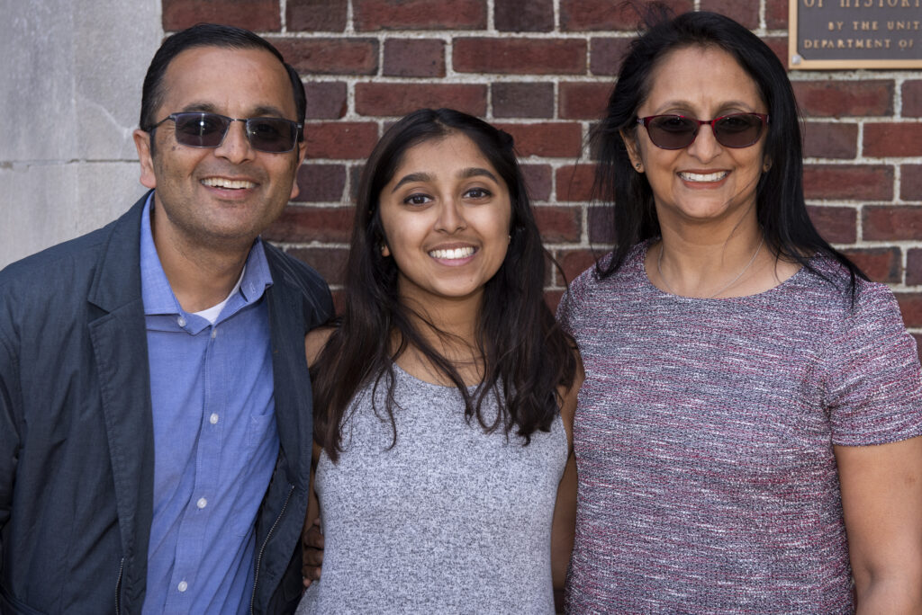 Student poses with parents at an event