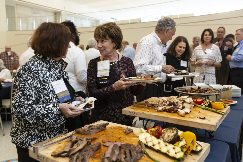 While at their Friday Night Reception, two 50th reunion celebrants reconnect while grabbing food
