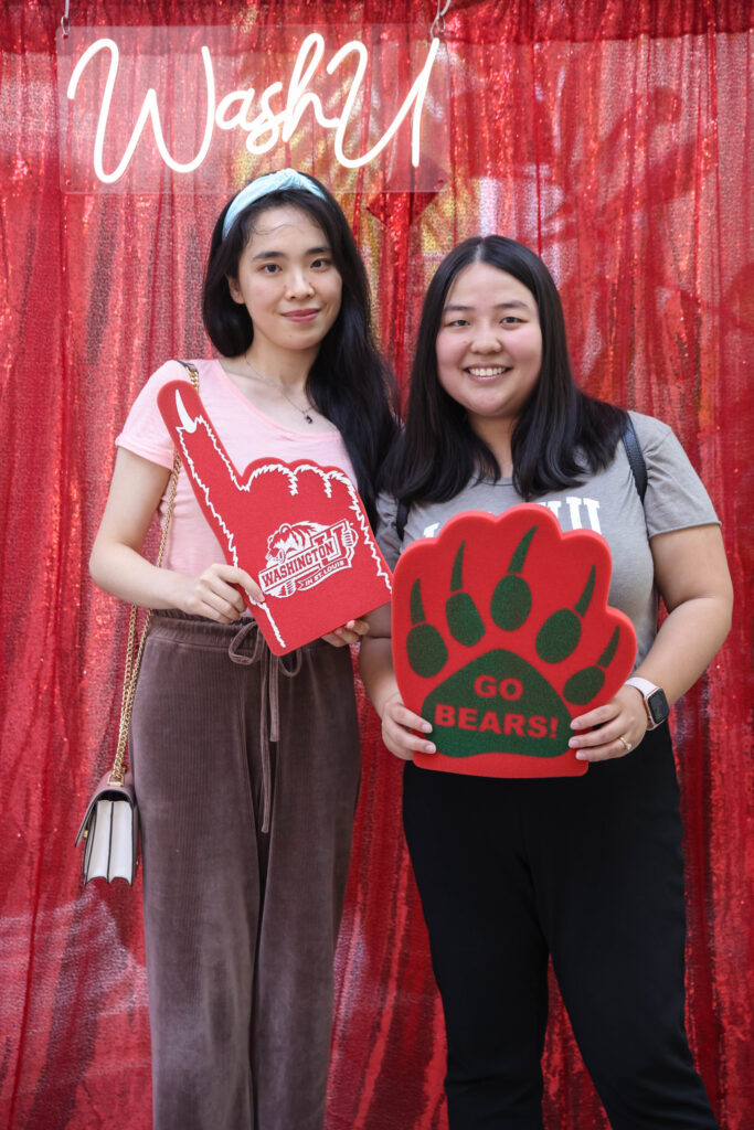 Two WashU stdents hold up school pride gear