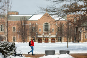 student walking across campus during winter