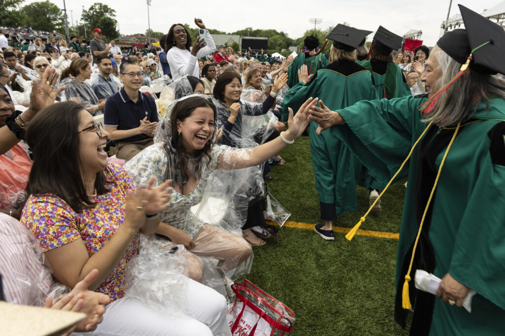 Golden Bear alums shake hands with guest at 2024 commencement 